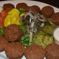 Falafel Platter · Spiced chickpea patties deep fried. Served over a bed of basmati rice and with side sauce.