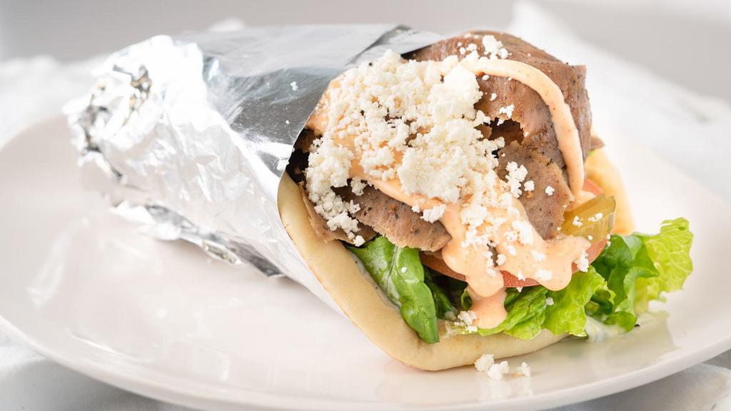 Lamb Gyro · Slices of slow roasted tender lamb gyro meat. Served in a warm pita with lettuce, tomato, onion, pickles, and tzatziki sauce. 

Add optional Spicy Garlic, Feta Cheese and Hummus with some curly fries to complete your meal.