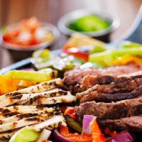 Fajitas · Marinated steak or chicken grilled with sliced onions and bell peppers, served with sour cre...
