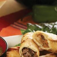 Beef Taquitos · Three shredded beef taquitos on flour tortillas with green tomatillo salsa.