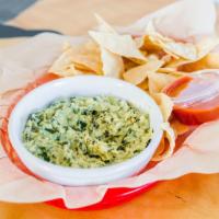 Spinach Fundido Dip · Organic spinach, white wine and creamy artichoke queso dip served with corn chips.