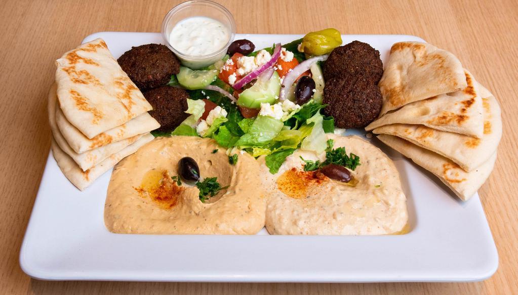Mediterranean Sampler · A vegetarian delight with Hummus, Baba Ghanoush, Greek Salad, and Falafels. Served with Taziki Sauce, and 2 Pita Bread.