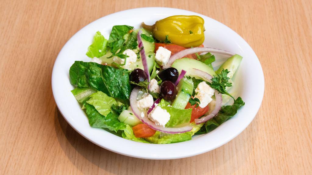 Side Greek Salad · Romaine Hearts, Tomatoes, Cucumbers, Red Onions, Feta Cheese, Olives, Pepperchine, and Homemade Greek Dressing.