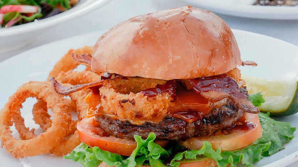 Wild West Burger · Half-pound Angus beef patty, bacon, cheddar, onions rings, BBQ sauce, cheddar, lettuce, tomatoes, and mayonnaise on a grilled brioche bun. Served with your choice of side. Per person.