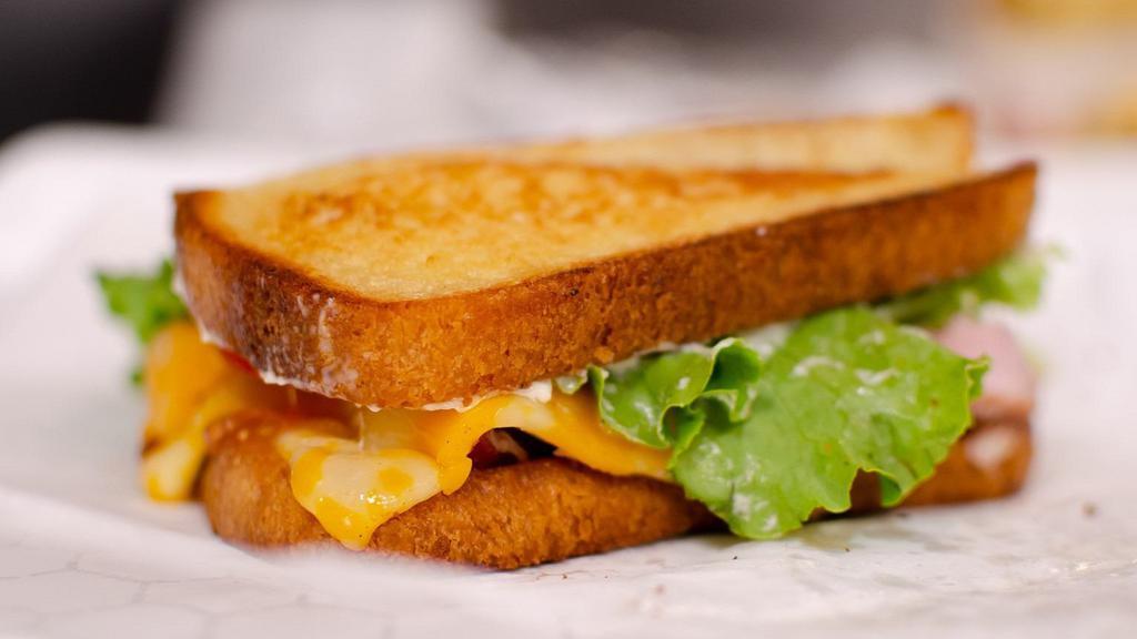 Honey White Deli Melt · Grilled honey white bread with Havarti and Colby jack cheeses, lettuce, tomato, and Queen's special sauce with a choice of bacon, ham, or turkey.
