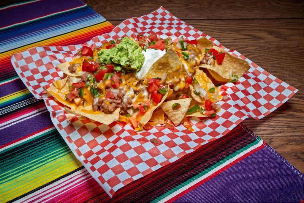 Nachos · Fresh tortilla chips covered with shredded cheese and loaded with refried beans, guacamole, sour cream, pico de gallo and smothered with our signature cheese sauce.