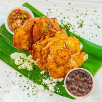 Patacones · Gluten free. Deep fried green plantains served with seasoned black beans, pico and roasted g...