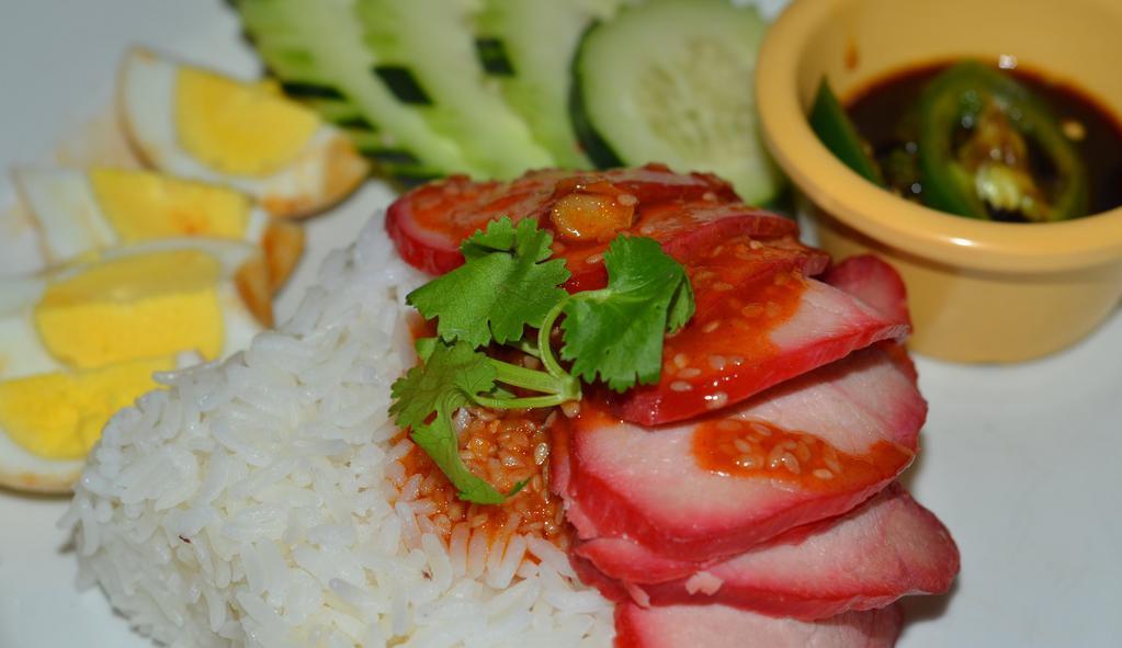 Khao Moo Dang · The most famous Thai-Chinese BBQ pork on the bed of steam vegetables and jasmine rice topped with egg, 
homemade sesame sweet & sour sauce, cucumber and cilantro. (You will love it)