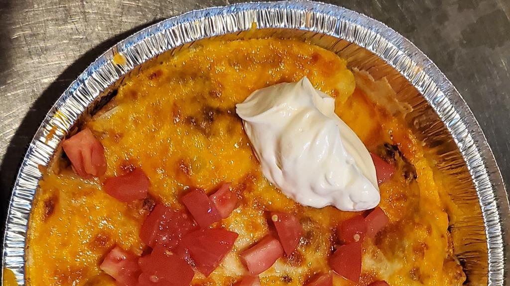 Mexican Pizza · Crisp flour tortilla topped with refried beans and choice of ground beef, chicken or picadillo. Topped with cheese, tomatoes and onions. Garnished with sour cream and guacamole.