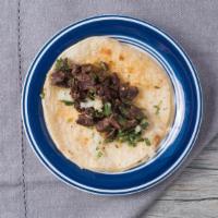 Carne Asada Taco · Made with a soft corn tortilla filled with cilantro and onion.