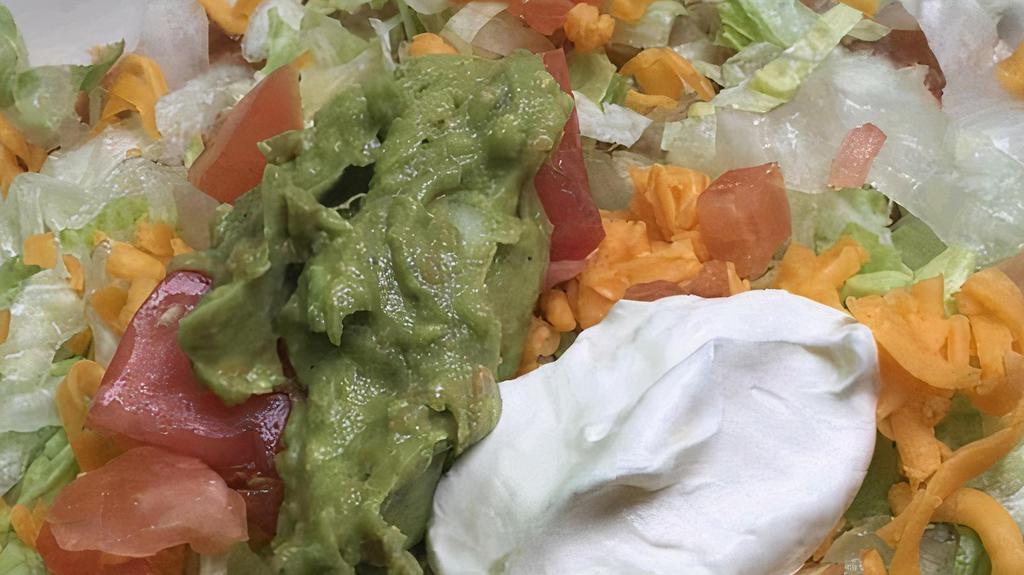 Deluxe Tostada · Bean with chicken or beef, guacamole and sour cream. Open faced tacos with bean and toppings, shredded lettuce, cheese and tomato.