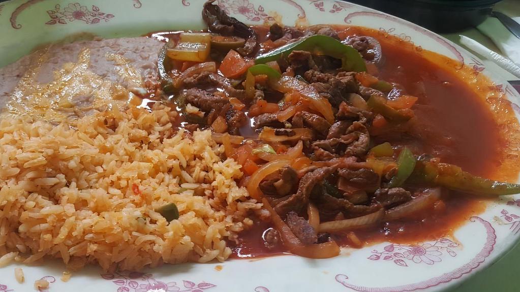 Steak Ranchero · Sliced pieces of sirloin steak fried with onion, green peppers, tomatoes and jalapenos peppers and Spanish sauce. Served with rice, beans and tortillas.