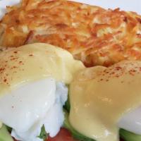 Avocado Benedict · English muffin topped with avocado and tomato slices, two poached eggs, and hollandaise sauc...