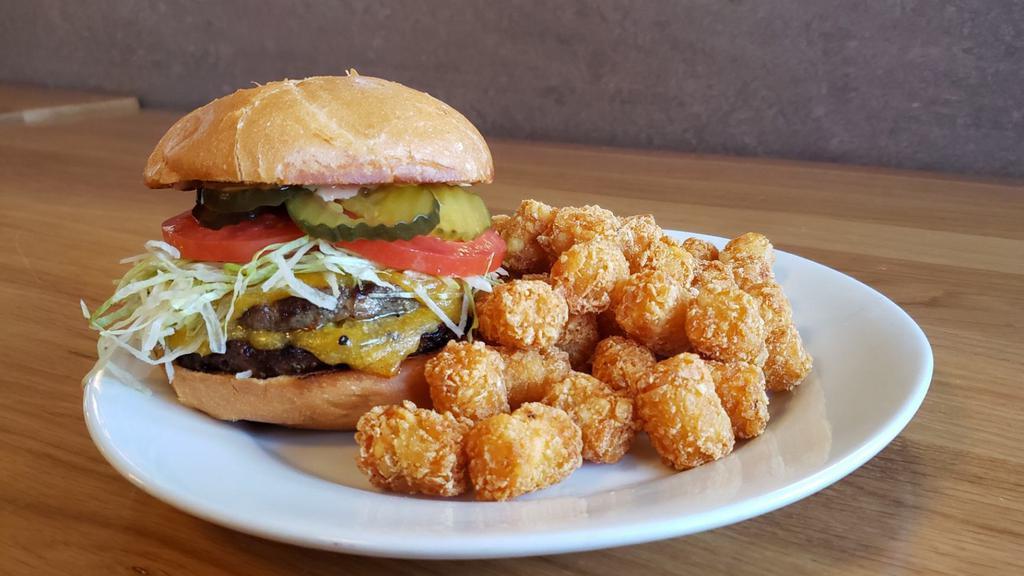 Jake Burger · Two 1/3 lb. fresh burger patties topped with 2 thick slices of Tillamook Cheddar Cheese. Served with lettuce, tomato, special dressing and pickles. Served with choice of side.