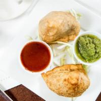 Samosa · Triangular pies stuffed with potatoes and peas, tempered with spices.