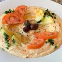 Hummus · Delicate mixture of chickpeas, garlic, tahini, salt, and lemon juice. Served with two warm P...