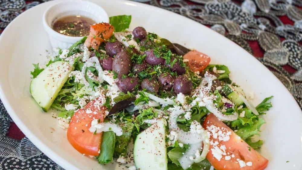 Greek Salad · Tossed crisp mixed greens with tomatoes, onion, cucumber, feta cheese, and Kalamata olives. Topped with our House Dressing.