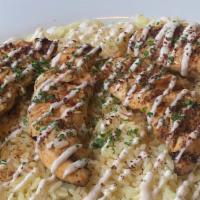 Garlic Lemon Chicken (Shish Tawook) · Tender Chicken Breast marinated in lemon, garlic, and spices. Served over a bed of rice, top...