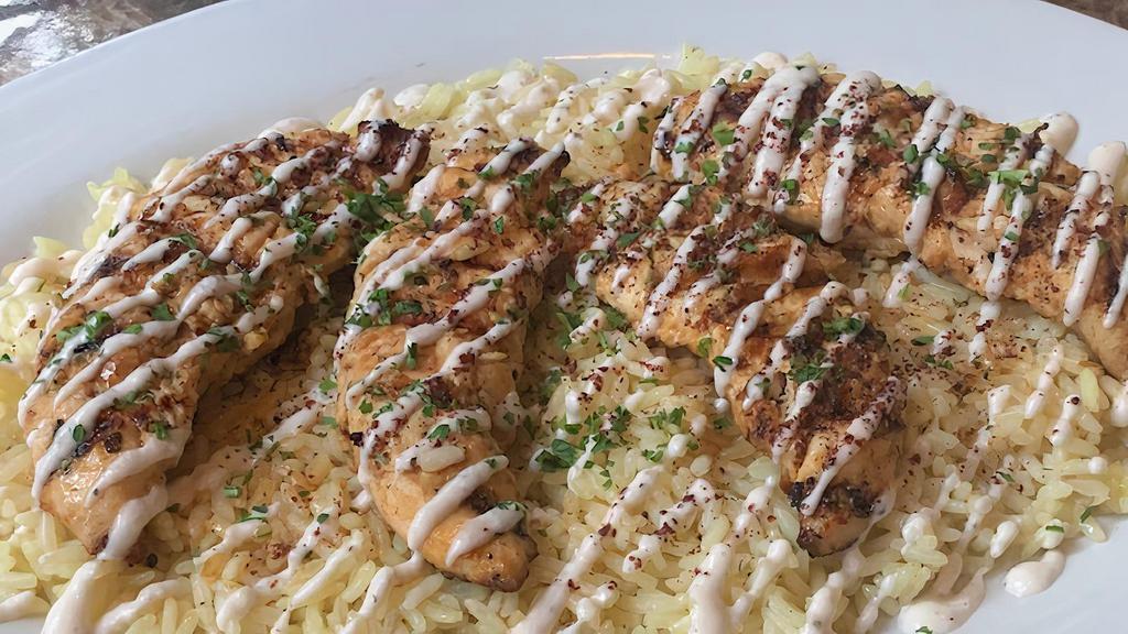 Garlic Lemon Chicken (Shish Tawook) · Tender Chicken Breast marinated in lemon, garlic, and spices. Served over a bed of rice, topped with house Garlic sauce.