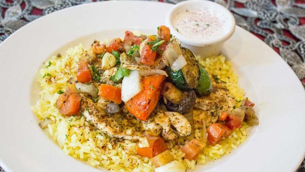 Taste Of Africa · Tender Chicken Breast served with charbroiled vegetables, topped with Sautéed garlic, onions, and tomatoes, seasoned with our house spices. Served over a bed of rice, topped with Garlic sauce.