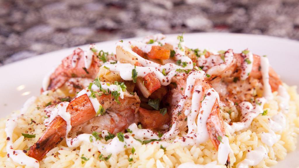 Mediterranean Prawns · Our signature dish of Mediterranean-style Prawns. Seasoned in our house Mediterranean Spices. Charbroiled. Served over a bed of rice with sautéed garlic, onions, and tomatoes, topped with house Garlic sauce.