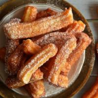 Churros · Mouth-watering fried dough pastry filled with cream and coated with cinnamon sugar, served w...
