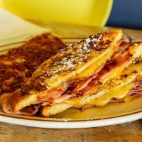 # French ‘Wich · French toast, bacon, ham, cheddar, bacon syrup, and powdered sugar. Served with hashbrowns.