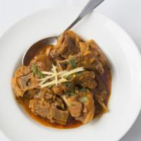 Goat Curry · Thick and chunky homestyle curry of onion-based sauce with sautéed onions, tomatoes, green c...