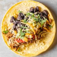 Pabellon Taco · Slow-cooked beef brisket, sweet peppers, onions, queso fresco, cabbage slaw, verde, and plan...