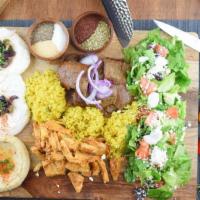 Byblos Package · Served with chicken shawarma, gyro meat, hummus, tzatziki sauce, rice, feta salad, and pita ...