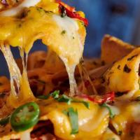 Loaded Nachos · Nachos loaded with cheddar cheese, sour cream, diced tomatoes, black olives, beans and beef ...