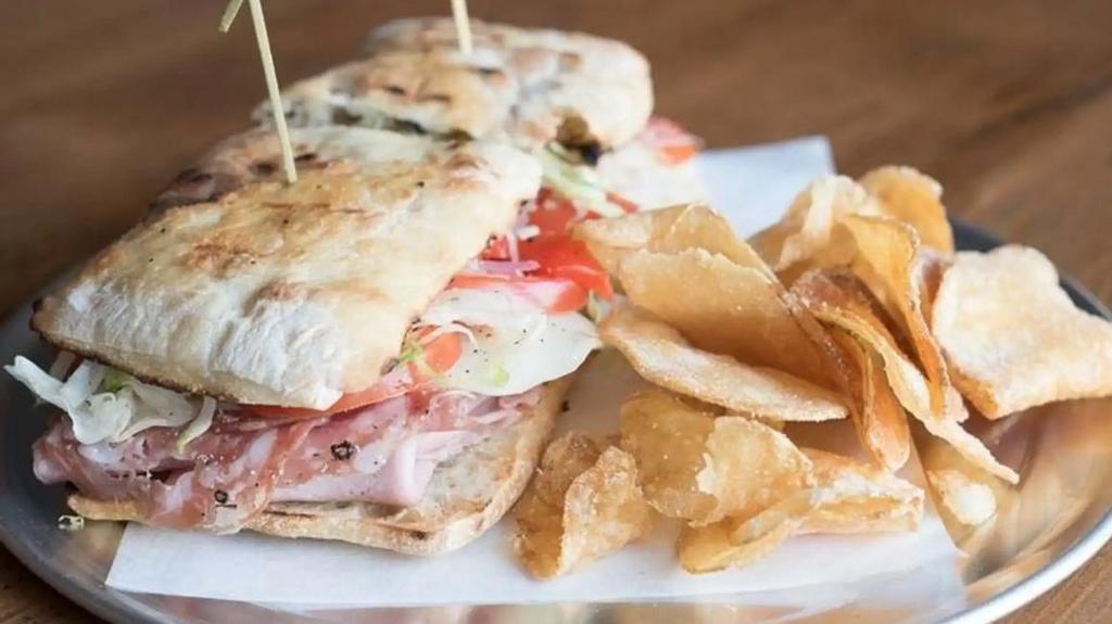 Italian Grinder · cured meats, provolone, tomato, sliced red onion, lettuce, hot peppers, oregano vinaigrette