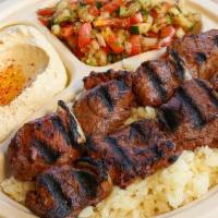 Filet Mignon Steak Kebab Plate · Two skewers of marinated filet mignon. Served with hummus, Israeli salad, rice, and two piec...