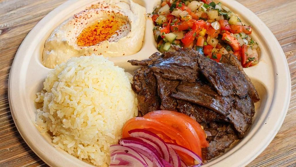 Beef Shawerma Plate · Beef sliced from a vertical spit with tahini sauce or tzatziki sauce. Served with hummus, Israeli salad, rice, and two pieces of pita bread.