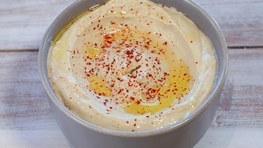 Hummus · Mashed chickpeas, blended with tahini, olive oil, lemon juice, salt, garlic, and spices. Served with pita.