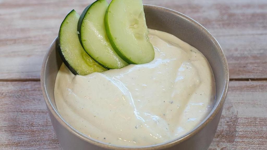 Tzatziki · Tzatziki is a dip made of yogurt and sour cream mixed with cucumbers, garlic, salt, olive oil, vinegar, and lemon juice, Served with pita.