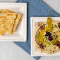 Hummus With Pita · Pureed chickpeas mixed with tahini sauce, lemon juice, and olive oil. Served with pita bread.