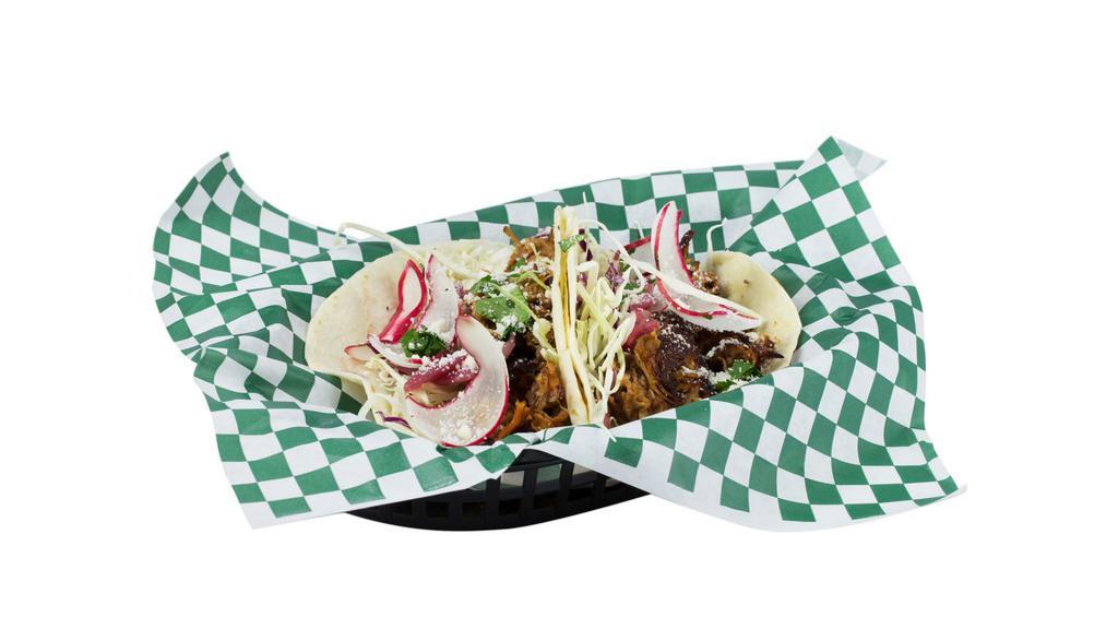 Carnitas · Two tacos with pickled red onion, cabbage, crema, cilantro, & cotija cheese.