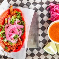 Pink Taco · El Pastor pork marinated in achiote with pineapple, cilantro, & pickled red onion.
