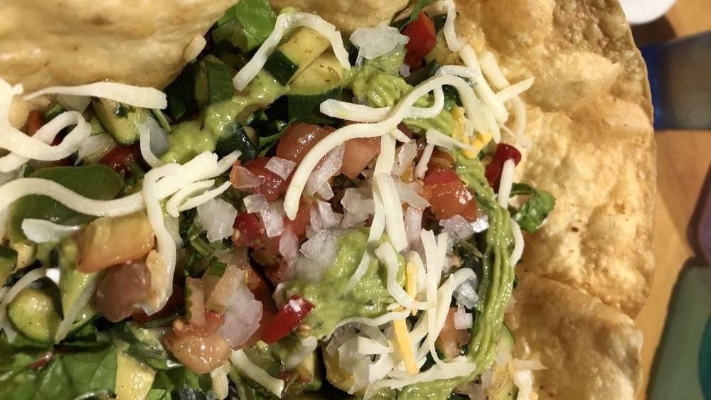 Veggie Taco Salad · Large Deep Fried Tortilla Shell Filled With Romaine Lettuce, Mexican Rice, Beans, Grilled Vegetable Medley (Finely Diced and Grilled zucchini, squash, carrots, onions, and oregano), Pico De Gallo, Guacamole, Sour Cream, Onion, and Cilantro