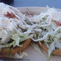 Sopes · Two thick cornmeal dough patties covered with beans, sour cream, lettuce, tomatoes cotija ch...