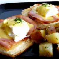 Eggs Benedict · Butter croissant, poached eggs, ham, hollandaise sauce & home fries