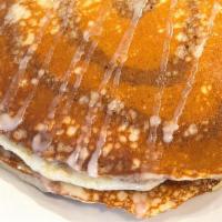 Cinnamon Roll Pancakes · Two pancakes with cinnamon swirl and cream cheese frosting.