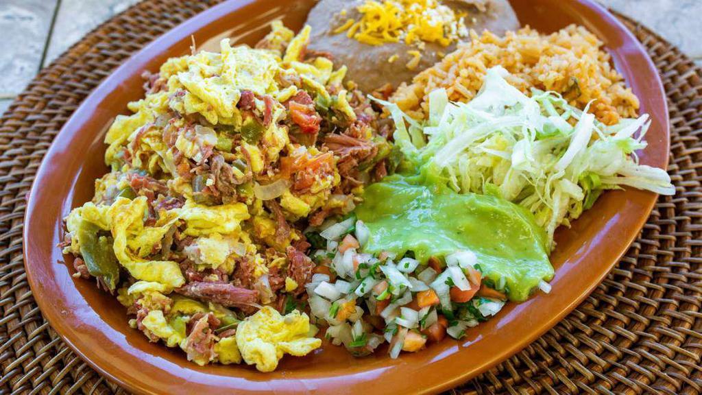 Machaca Plate · Shredded beef (cooked with bell pepper, onion and tomato) with eggs, lettuce, guacamole and salsa mexicana. Served with rice and refried beans. Three corn or one flour tortilla. No substitutions.