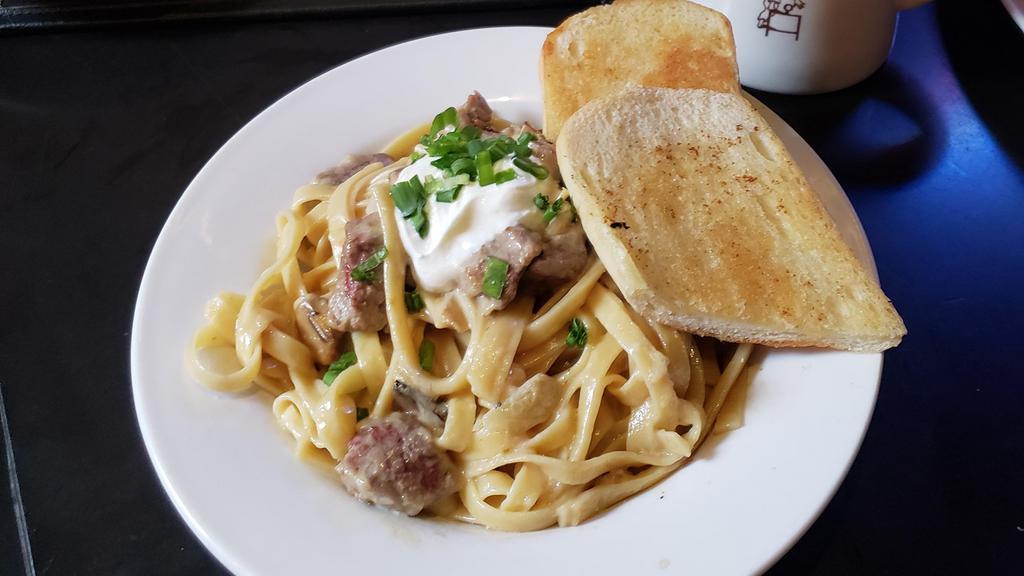 Beef Stroganoff · Tenderloin tossed with fettuccine in a mushroom cream sauce and topped with sour cream and green onions. Served with garlic bread.