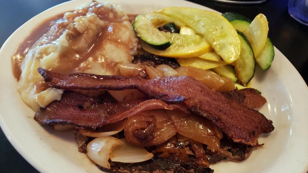 Liver & Onions · Dipped in buttermilk, hand-breaded then grilled with lots of onions, topped off with a strip of bacon and served with veggies, mashed potatoes and beef gravy.