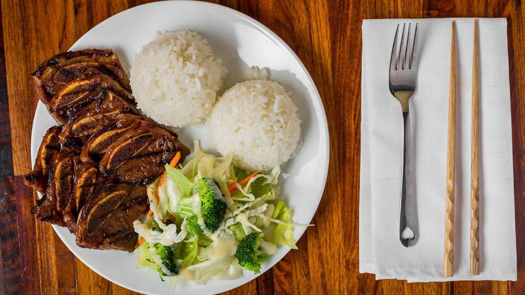 Beef Short Ribs · Kalbi beef served with rice and salad.