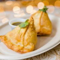 Samosa (2 Ct.) · Two crispy pastries stuffed with potatoes, peas, and secret spices.  
Served with a tamarind...