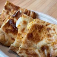 Naan Quesadillas · Cheese baked into freshly made naan and garnished with cilantro. Served with a side of tikka...