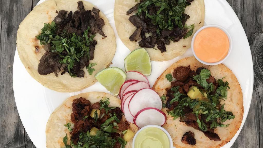 Taco Plate · Two tacos with your choice of meat, cilantro, onion, and radishes, with a side of rice and beans.
